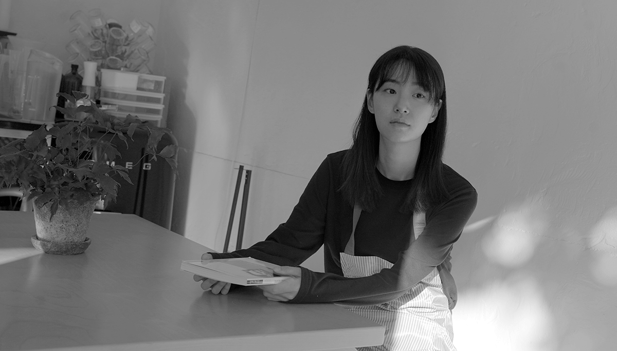 탁자 앞에서 책을 들고 있는 혜리
