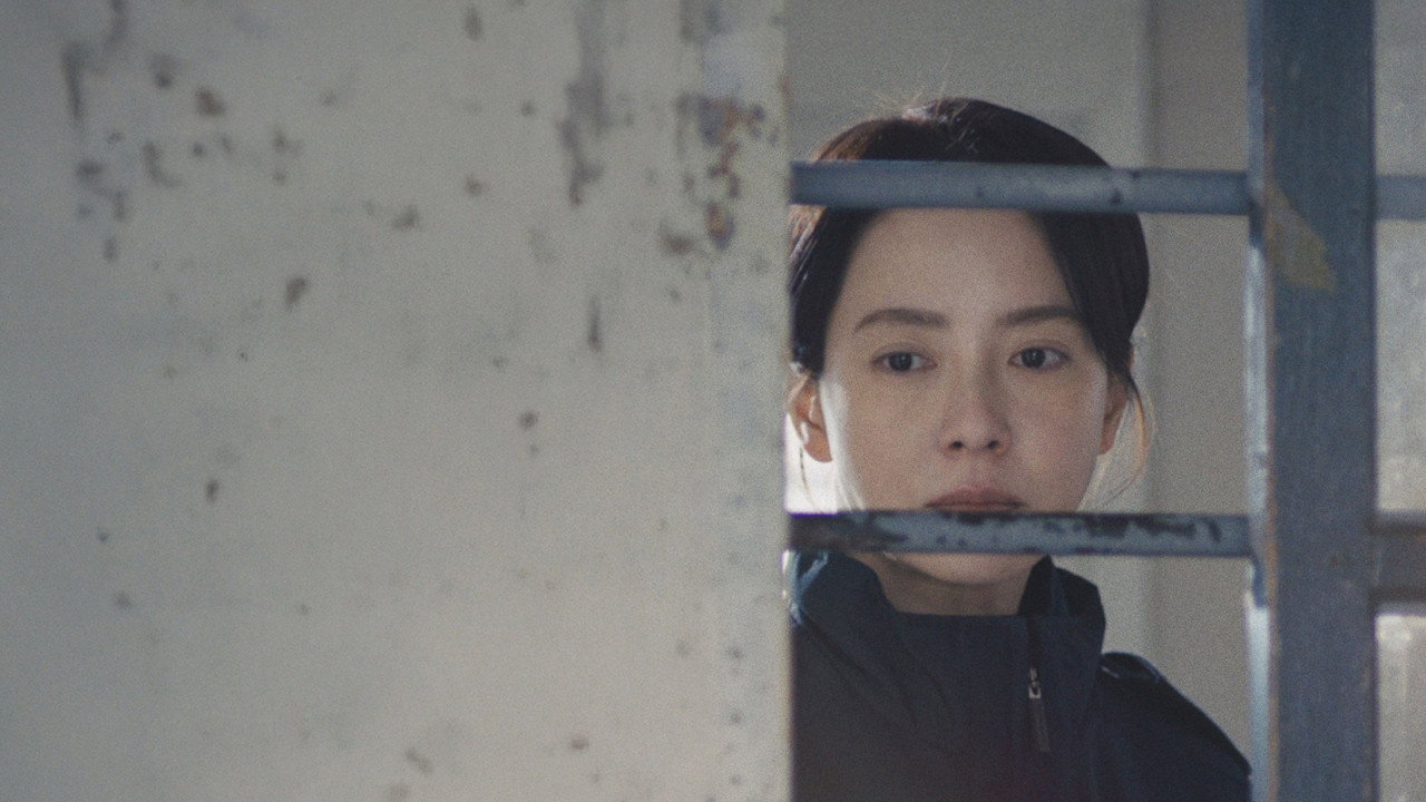 철창과 벽 사이 좁은 틈으로 여성의 얼굴이 보인다