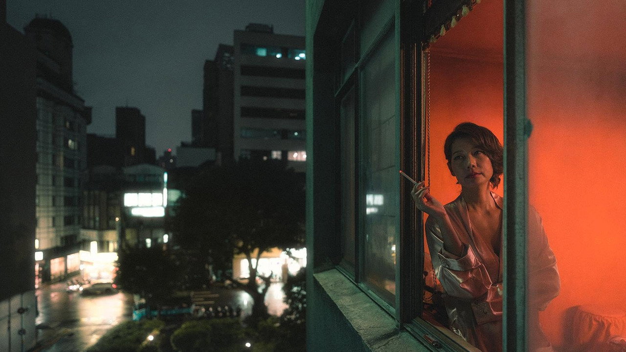 밤의 도시와 불이 켜진 창문 안의 인물